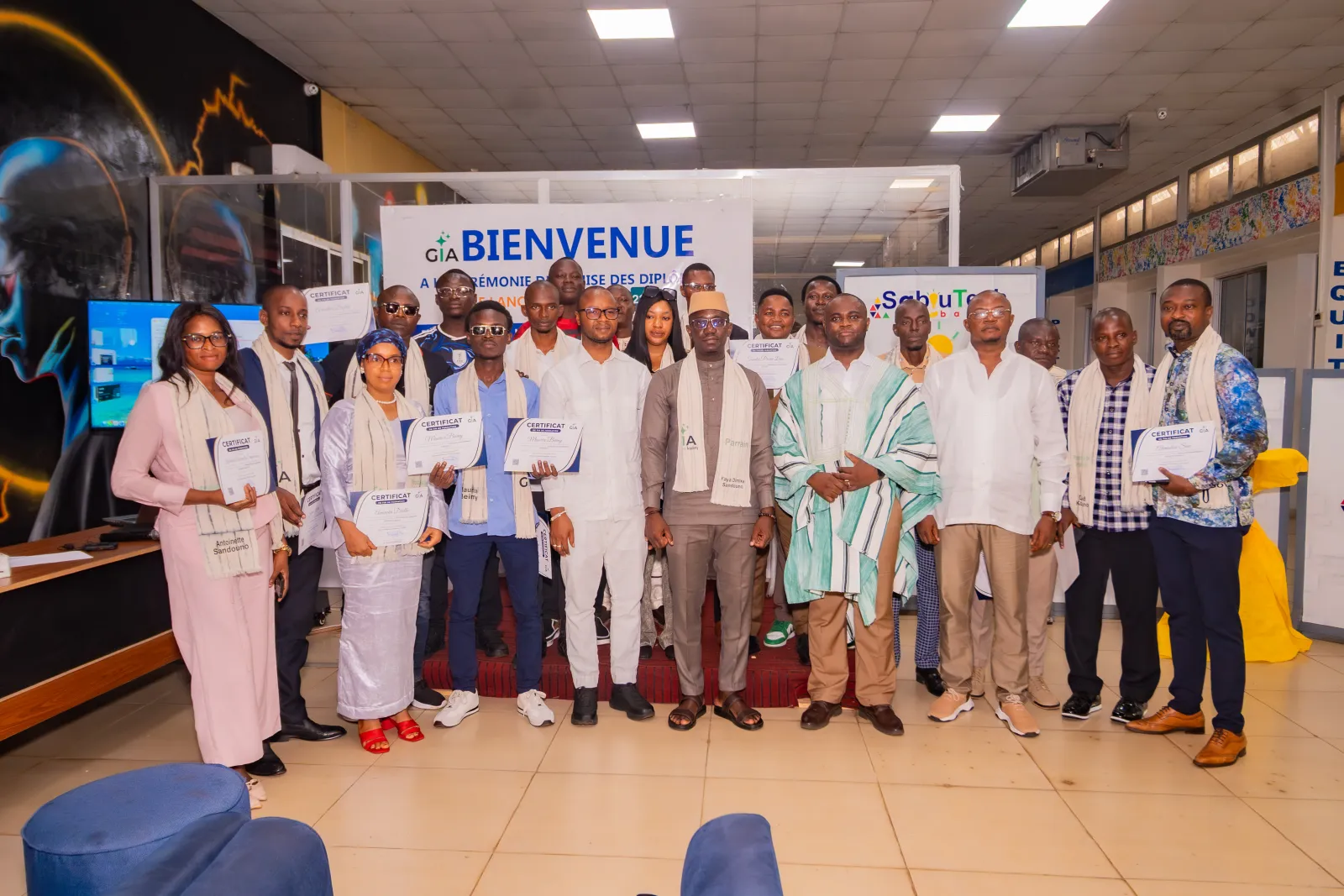 Photo de groupe des lauréats de la première promotion de GuineeInnov' Academy avec leur certificat, entourés du parrain et des officiels, à Conakry